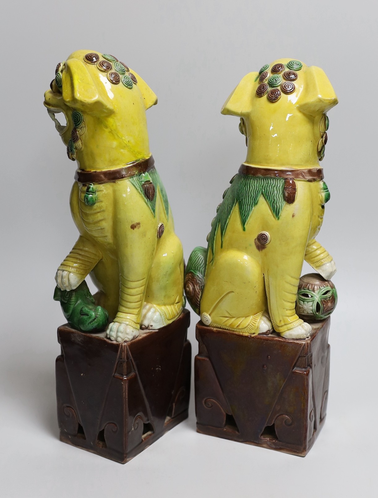 A pair of tall Chinese sancai glazed Buddhist lions, Republic, 36cms high